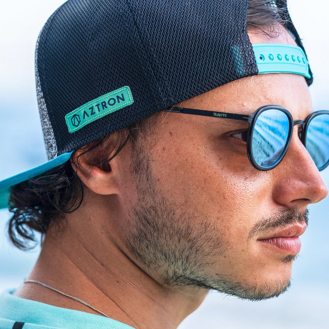 Hombre con el jockey Aztron Full Logo y lentes de sol, vista de perfil