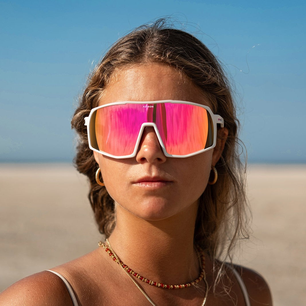 Mujer en la playa con los lentes de sol polarizados Aztron Miami rosados