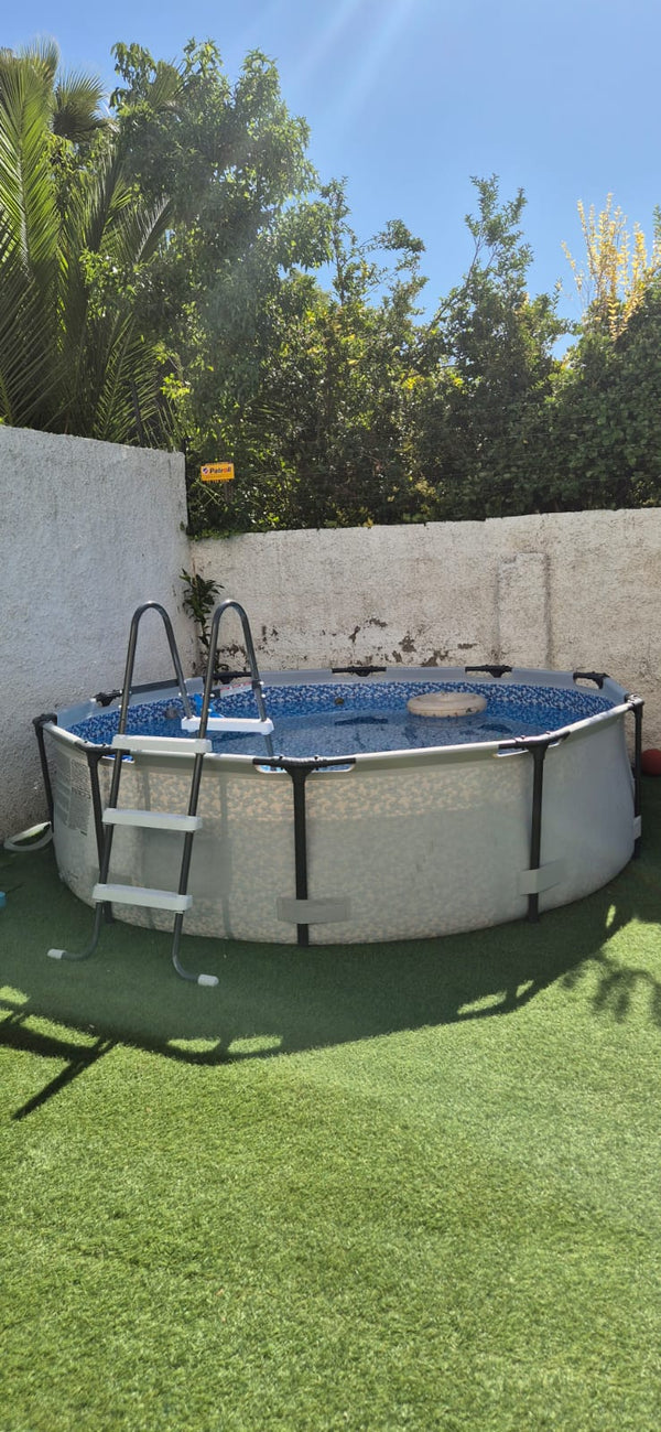 Piscina estructural redonda INTEX con escalera instalada en un jardín con pasto