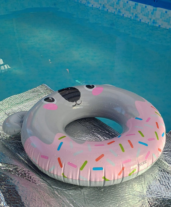Flotador inflable INTEX con forma de dona rosa al borde de una piscina