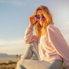Mujer en la playa al atardecer con los lentes de sol Aztron Dream