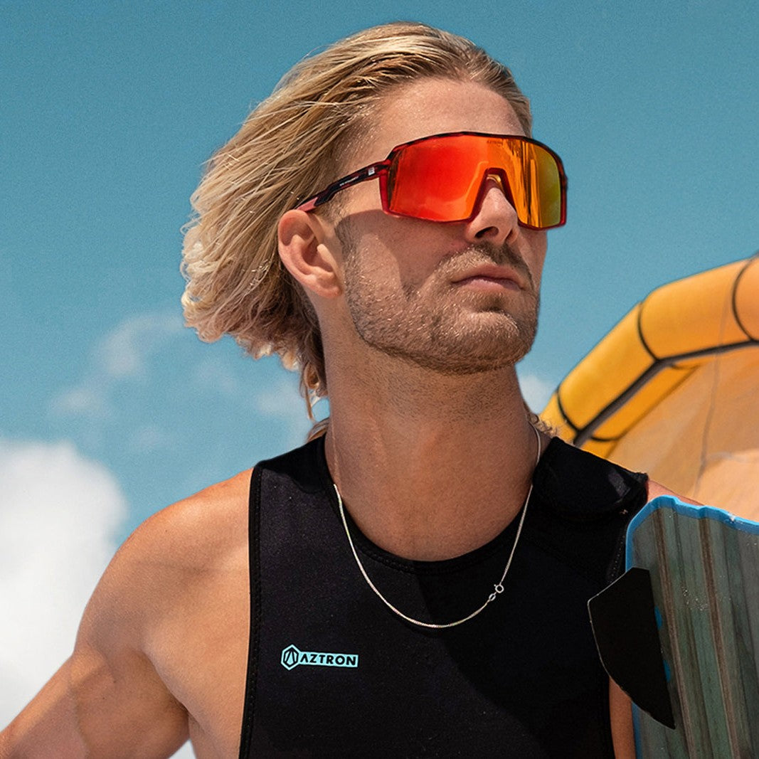 Hombre en la playa con los lentes de sol polarizados Aztron Halo rojos