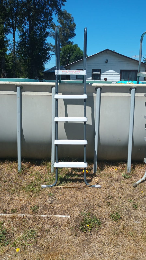 Escalera INTEX instalada en una piscina estructural, en un patio con pasto