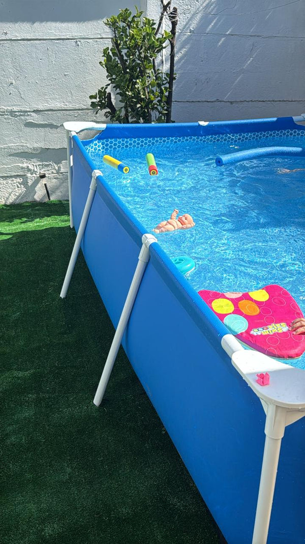 Piscina estructural rectangular INTEX armada sobre el pasto con flotadores dentro